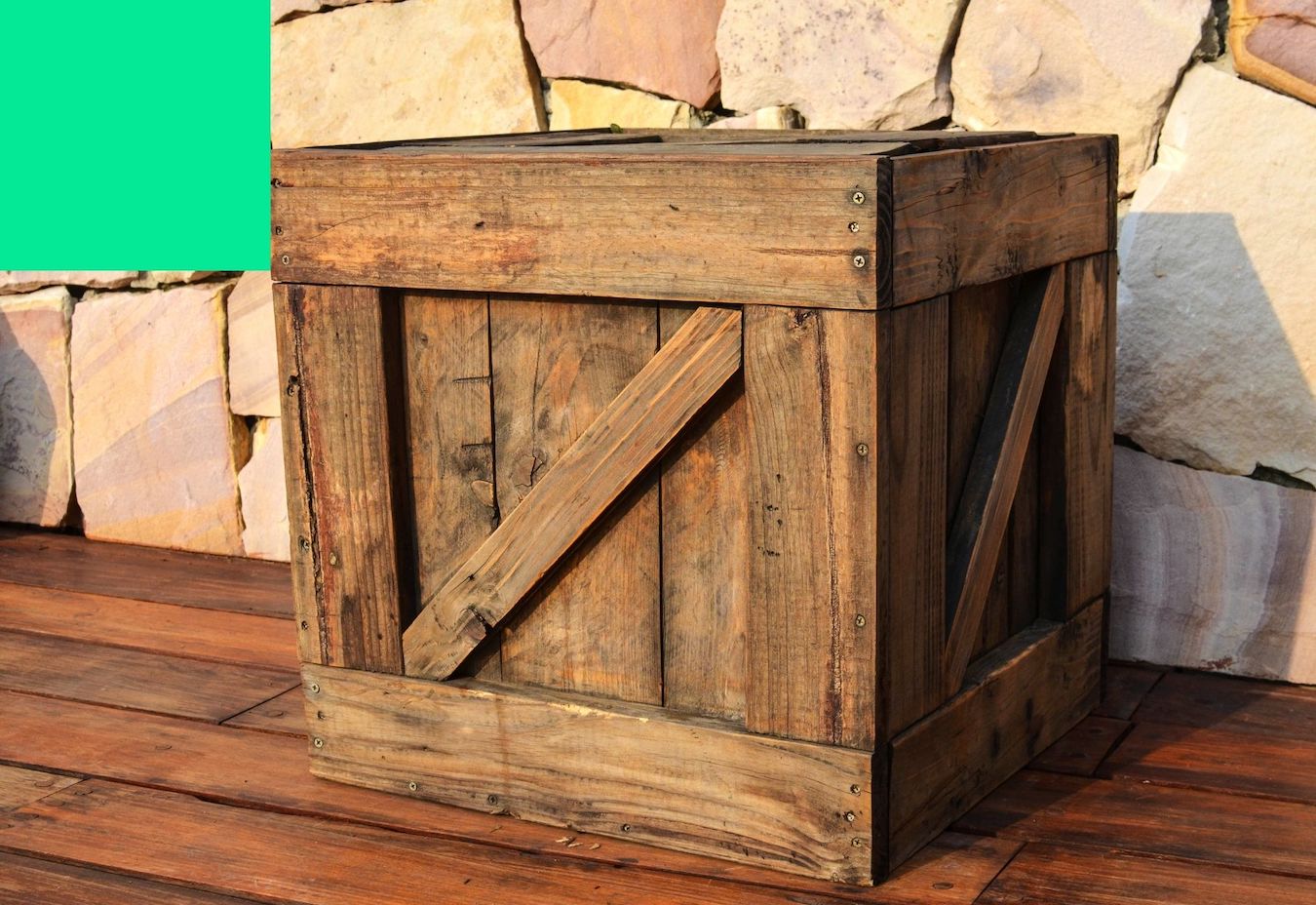 A wooden crate sits in the ground. It is used for wrapping and shipping paintings.
